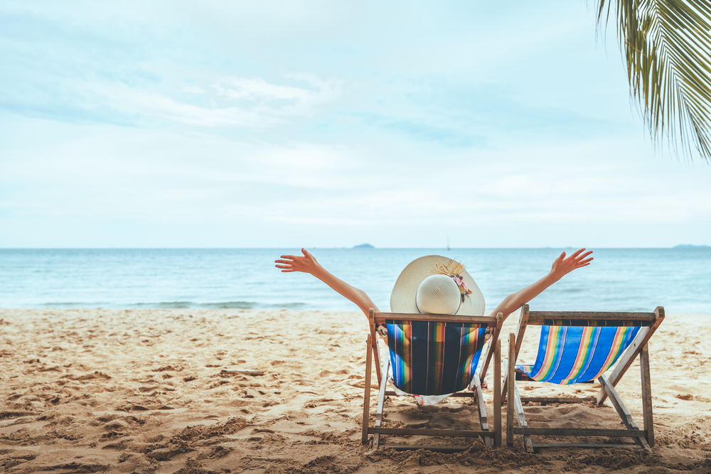 person sitting in lounge chair at the beach