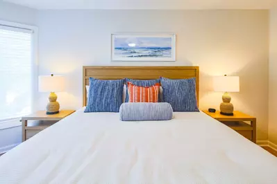 The bedroom features a king bed with night stands and reading lamps.