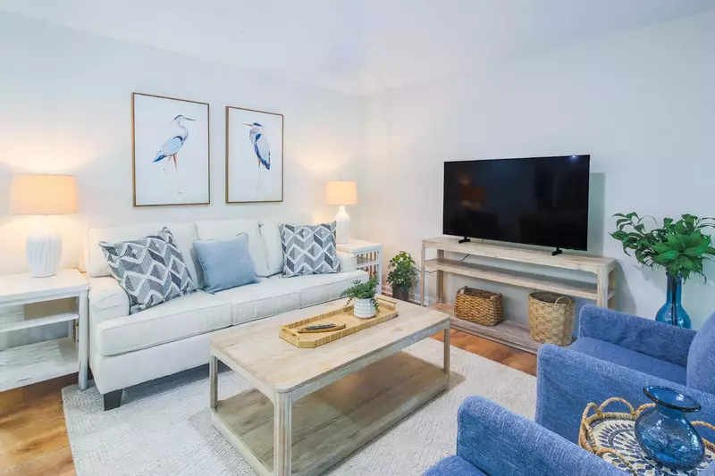 The living room features a queen sleeper sofa, smart TV and two arm chairs.