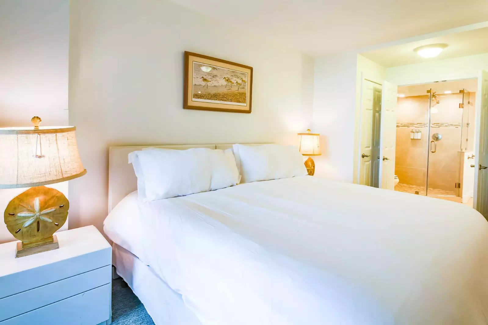 The en suite bathroom is located through the double doors on the right side of this photo.