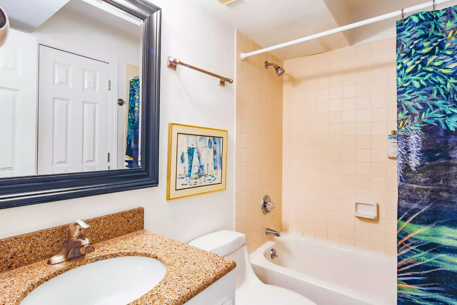 This bathroom features a vanity and a shower/tub combo.