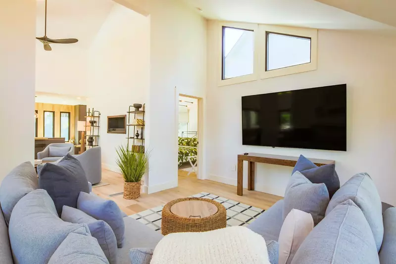 The living room, with its spacious sectional sofa, is located near the back deck.