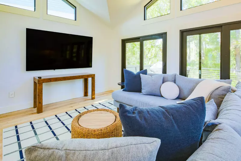 The living room has a wall-mounted large screen TV.