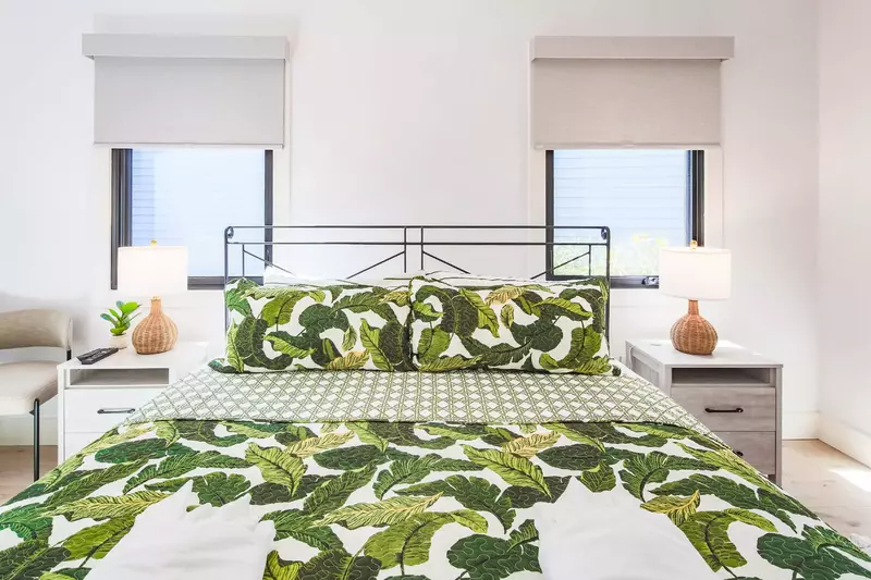This guest bedroom has a king bed, night stands with reading lamps and a chair.