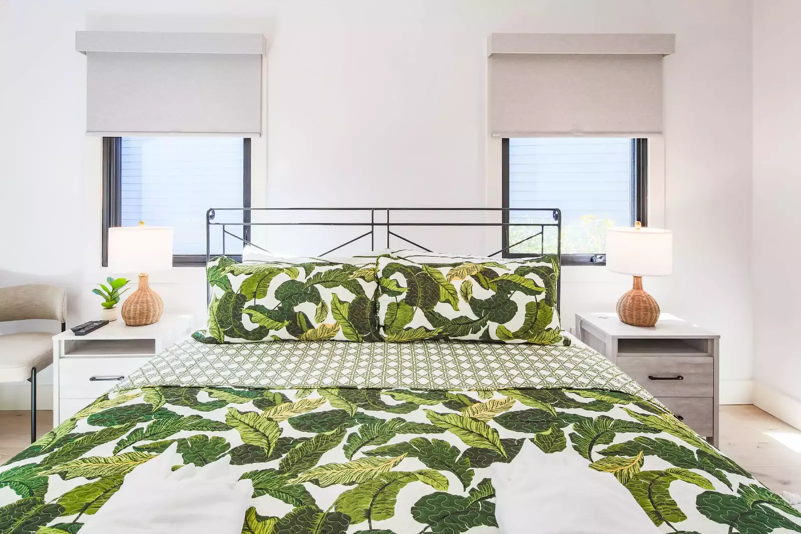 This guest bedroom has a king bed, night stands with reading lamps and a chair.