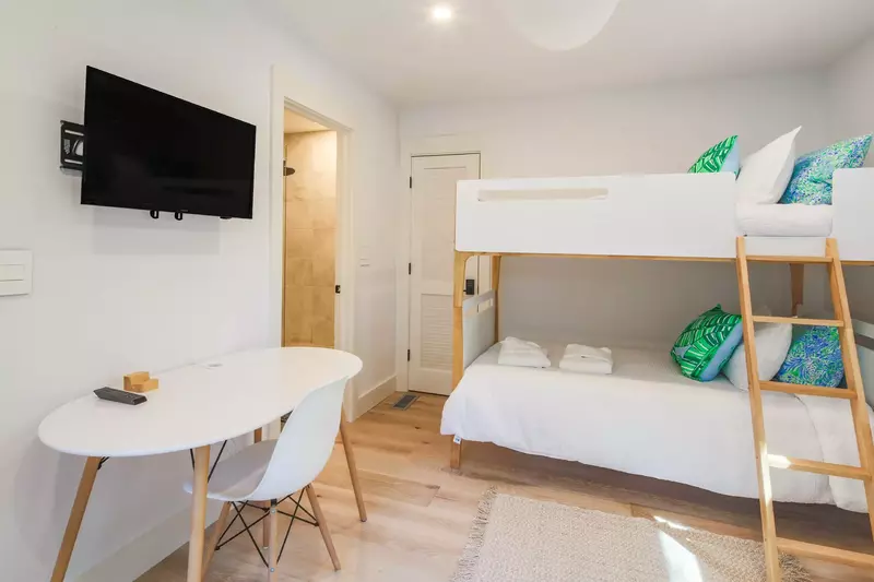 The bunk room also features a desk, wall-mounted smart TV and an en suite bathroom.