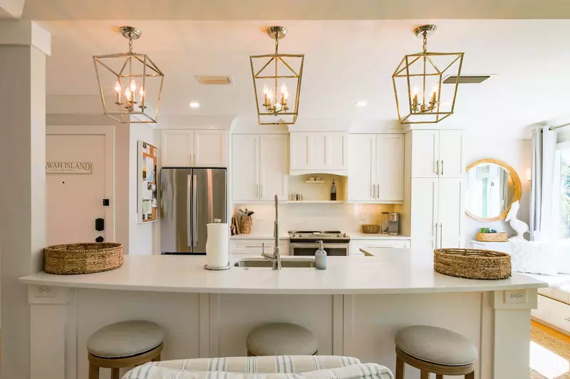 The spacious kitchen features white cabinetry, stainless steel appliances and counter seating.
