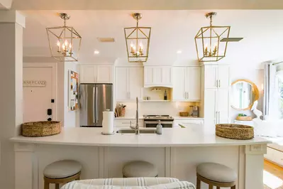 The spacious kitchen features white cabinetry, stainless steel appliances and counter seating.