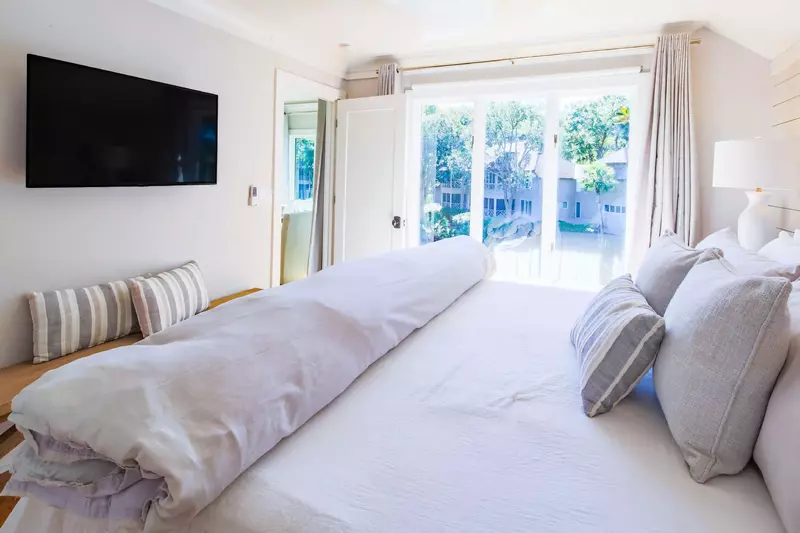 The master suite also has a wall-mounted TV, bench and lagoon views.
