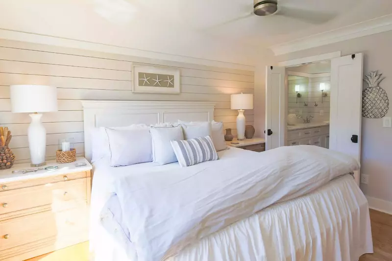The en suite bathroom is located through the double doors on the right side of this photo.