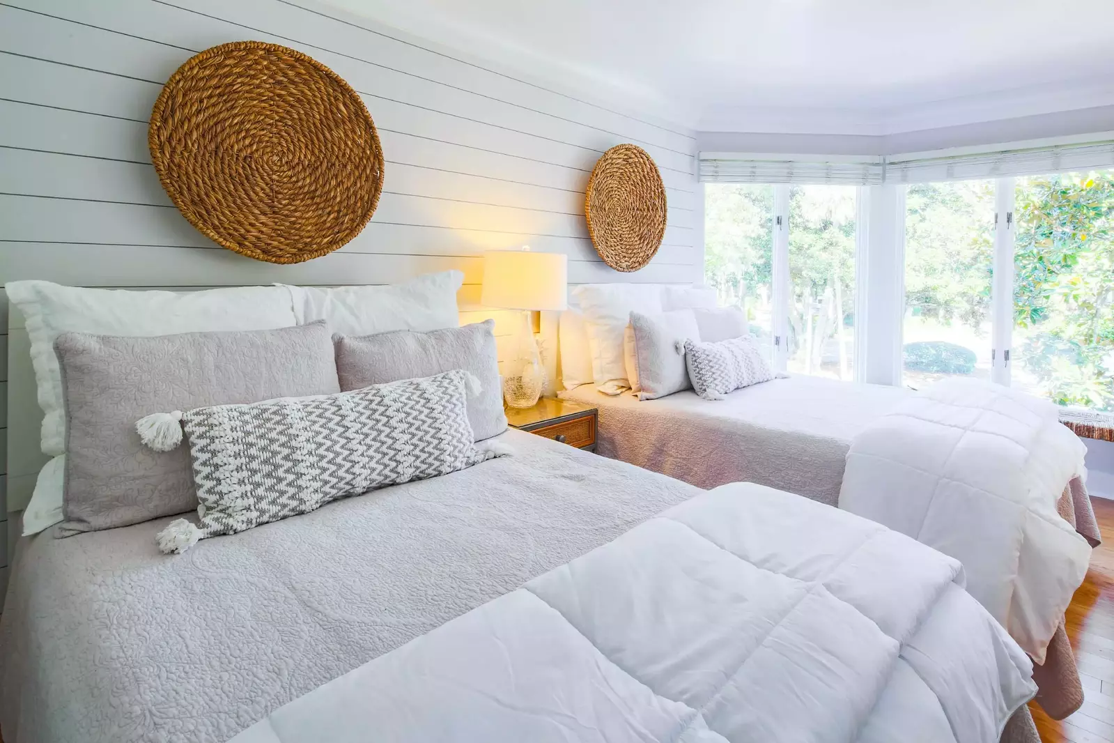The guest bedroom features two full beds and a shiplapped wall