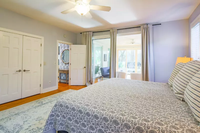 The master suite features a king bed and sliding door access to a sun-drenched seating area.