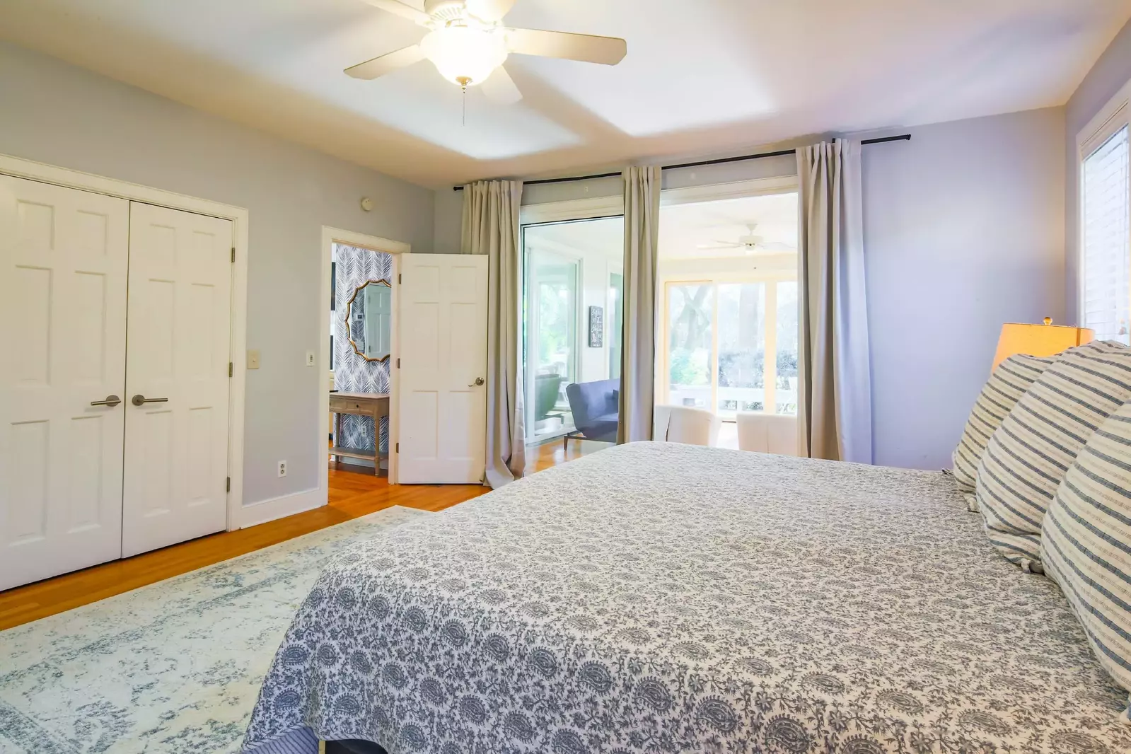 The master suite features a king bed and sliding door access to a sun-drenched seating area.
