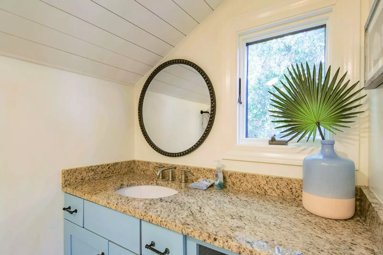 The en suite bathroom features a spacious vanity and shiplap ceilings.