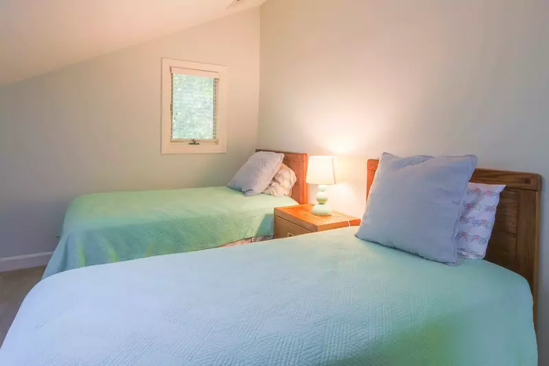 The twin suite features two twin beds and a night stand with reading lamp.