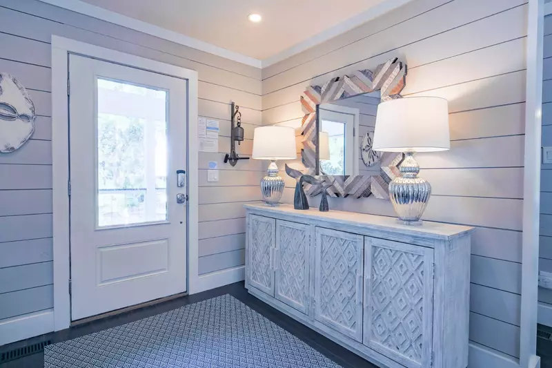 When you enter the front door, you will find this entrway with shiplap walls and coastal-themed decor.