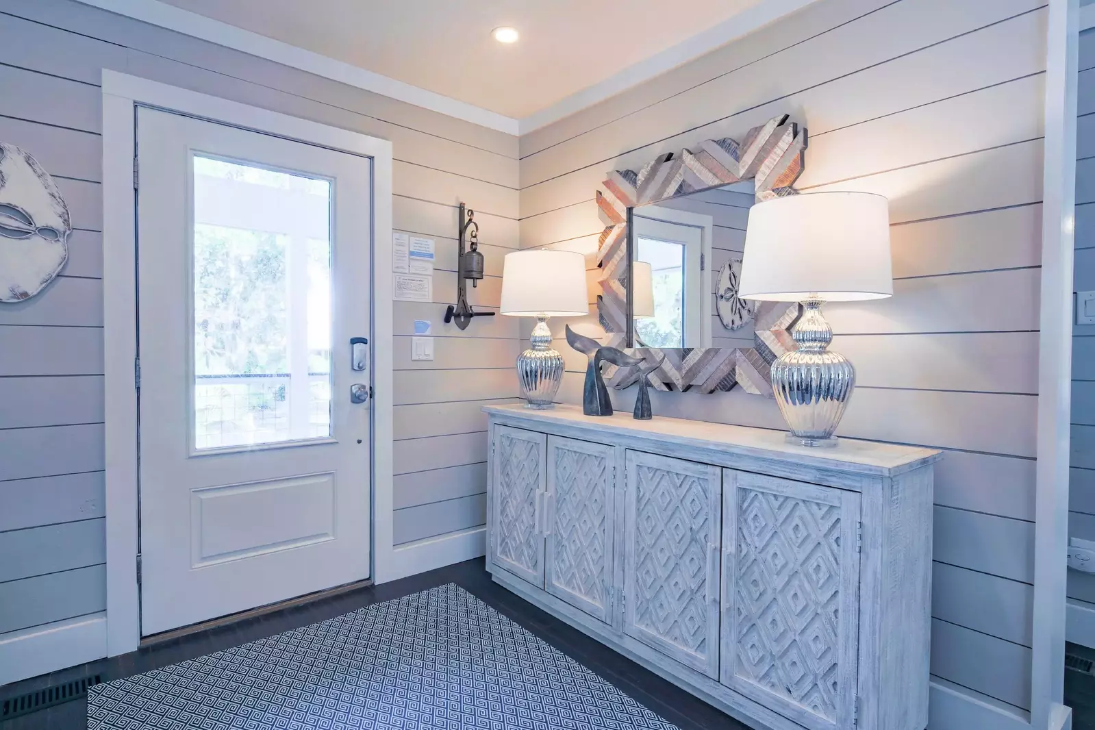 When you enter the front door, you will find this entrway with shiplap walls and coastal-themed decor.