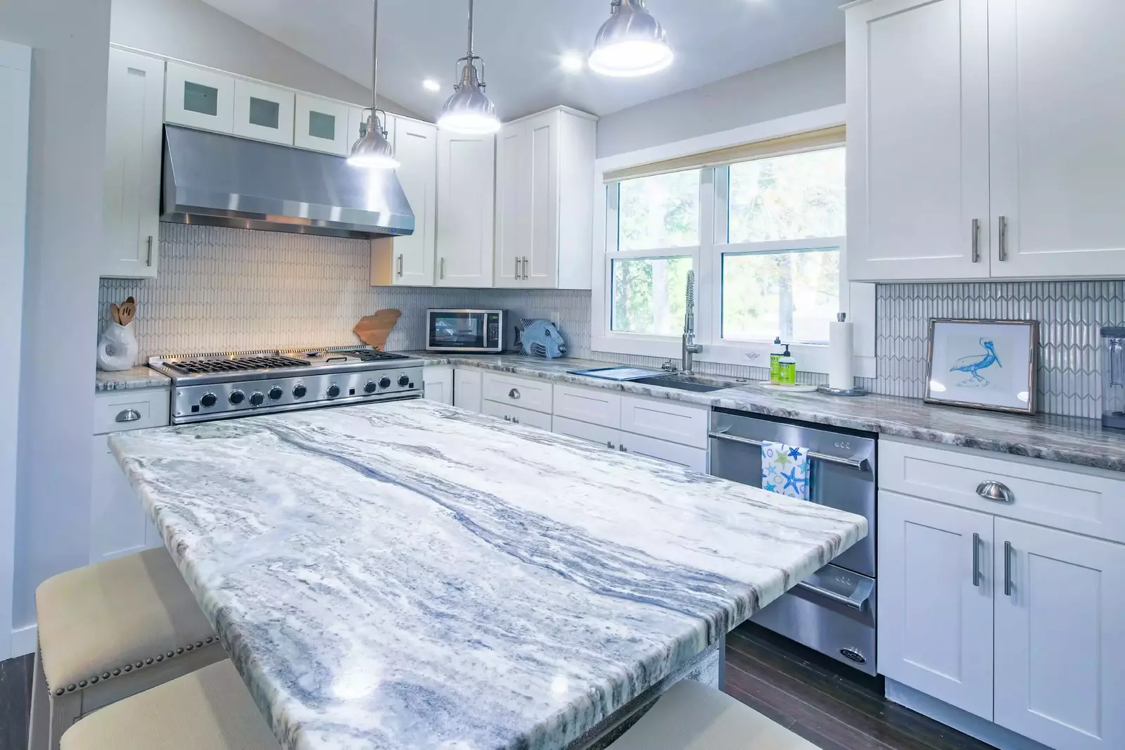 The kitchen features a beautifully-tiled backsplash as well as gas range with hood, dishwasher & microwave.