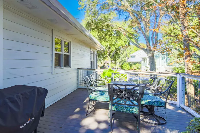 The screened porch connects to the side deck, which has a gas grill and outdoor dining table.