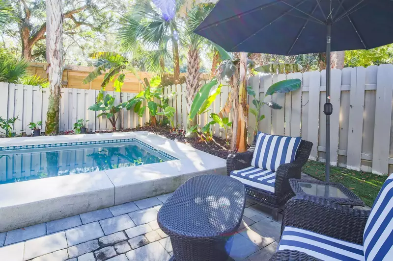 This seating area with umbrella near the pool enables you to comfortably watch your kids swim in the pool.