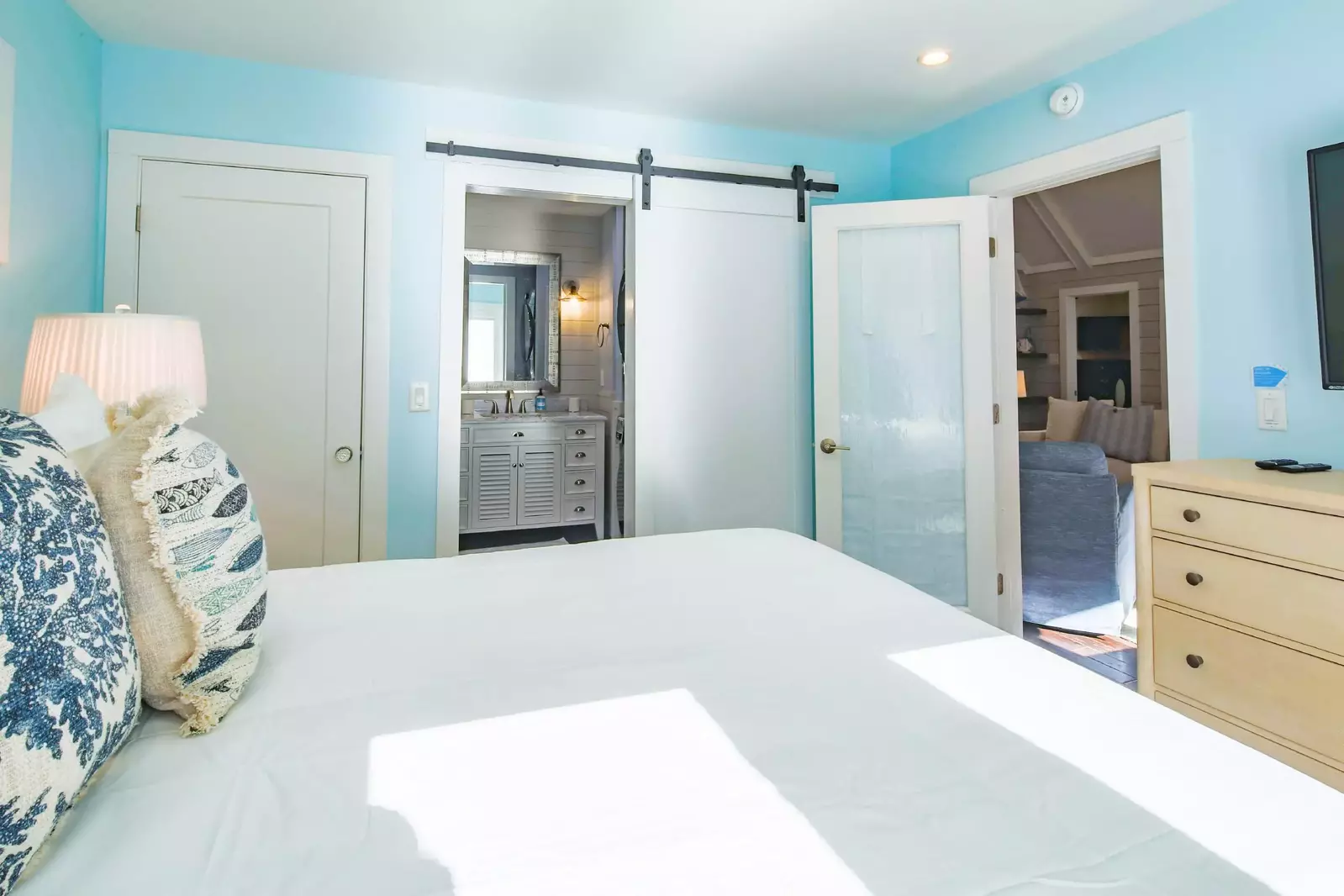The en suite bathroom for the primary suite is located just inside this barn door.
