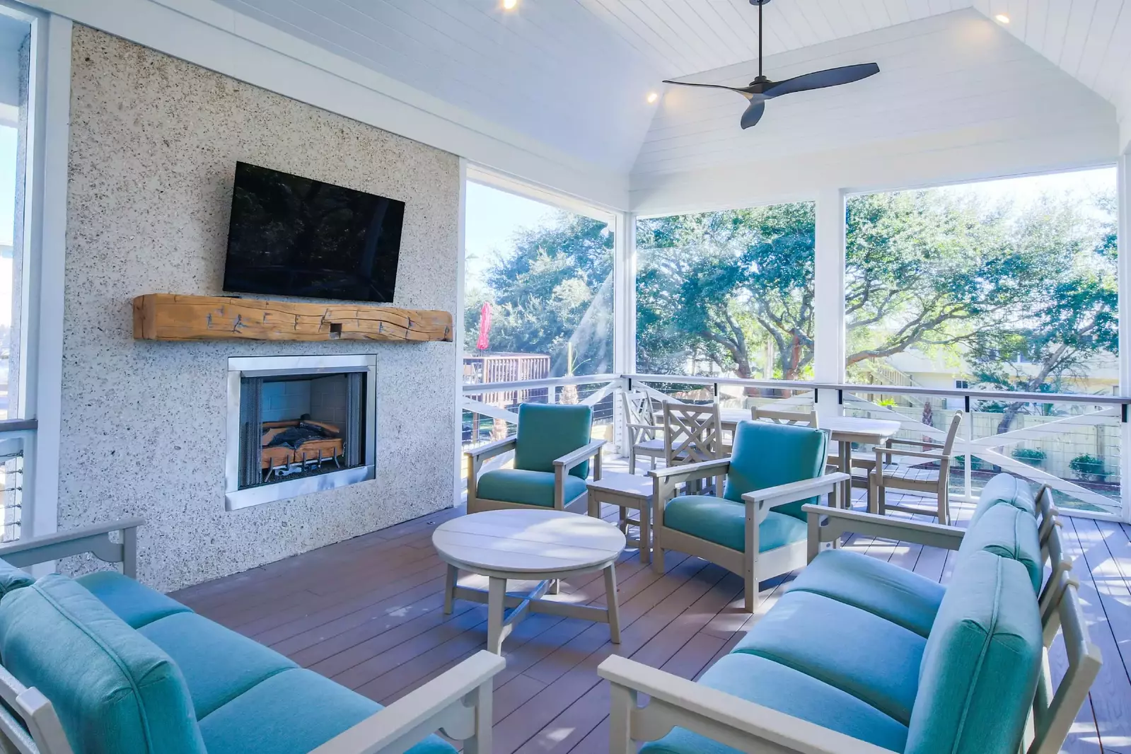 The screened porch overlooks the backyard and features a seating area and outdoor dining table.