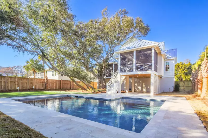 The pool is surrounded by a travertine patio and large backyard.