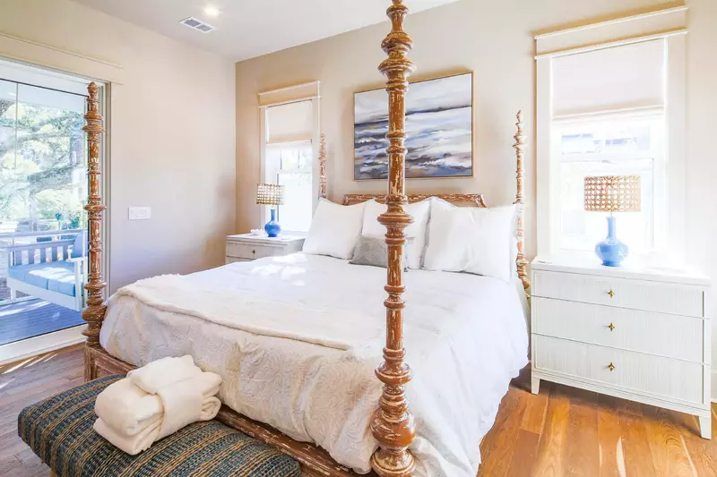 The primary suite features a king bed, bench and night stands with reading lamps.