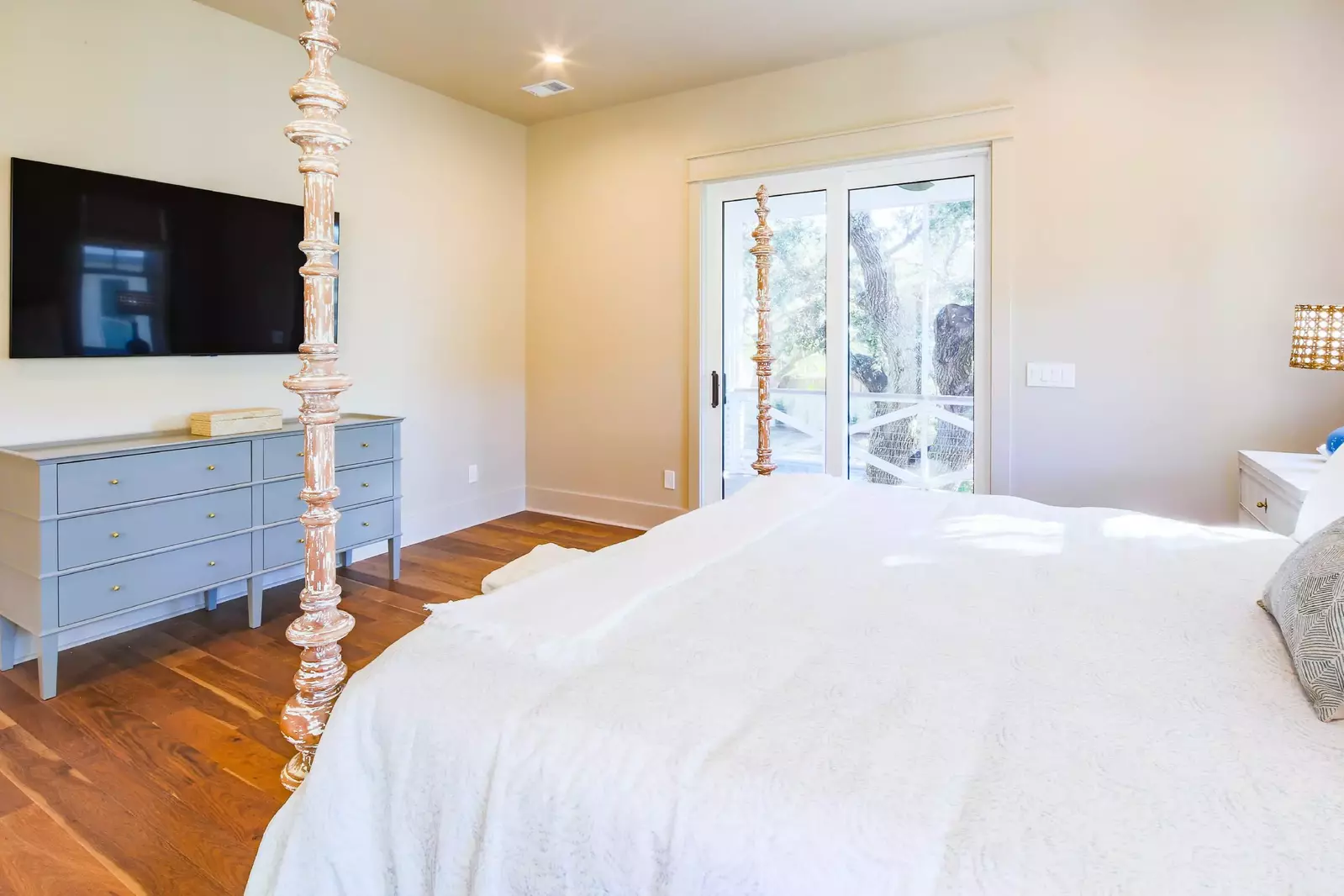 The primary suite also has a dresser, wall-mounted TV and access to a private balcony.