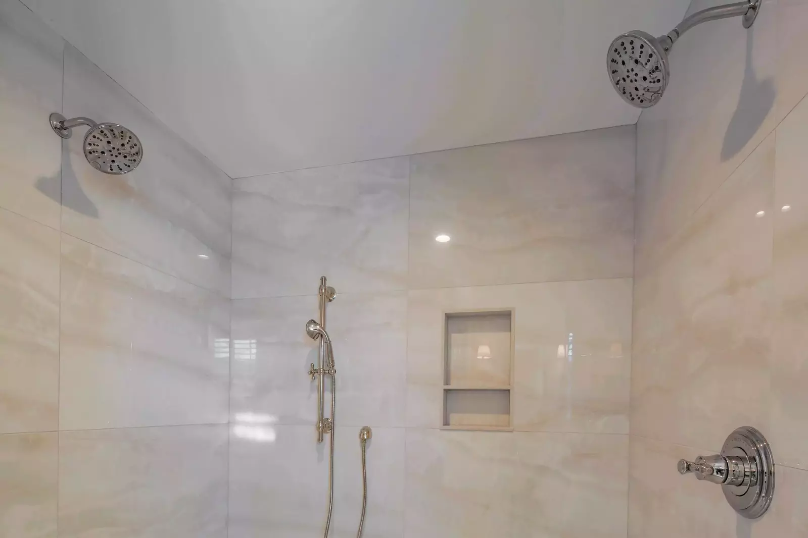 The walk-in shower in the primary bathroom has three shower heads.