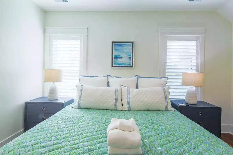 The upstairs king suite features a king bed and night stands with reading lamps.