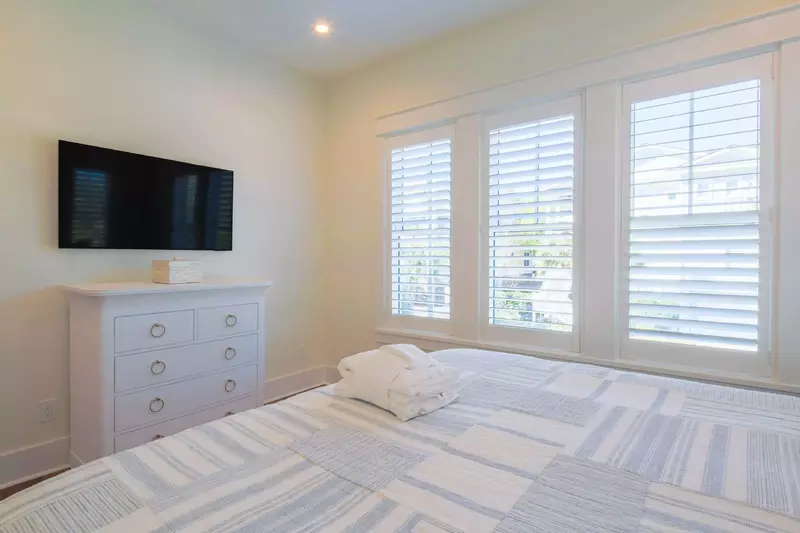 The downstairs guest bedroom also has a dresser and wall-mounted smart TV.