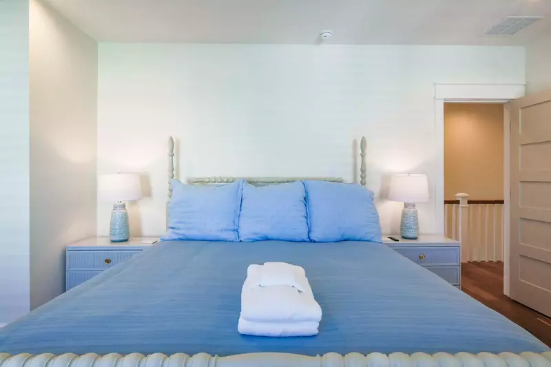 The upstairs guest bedroom features a king bed and night stands with reading lamps.