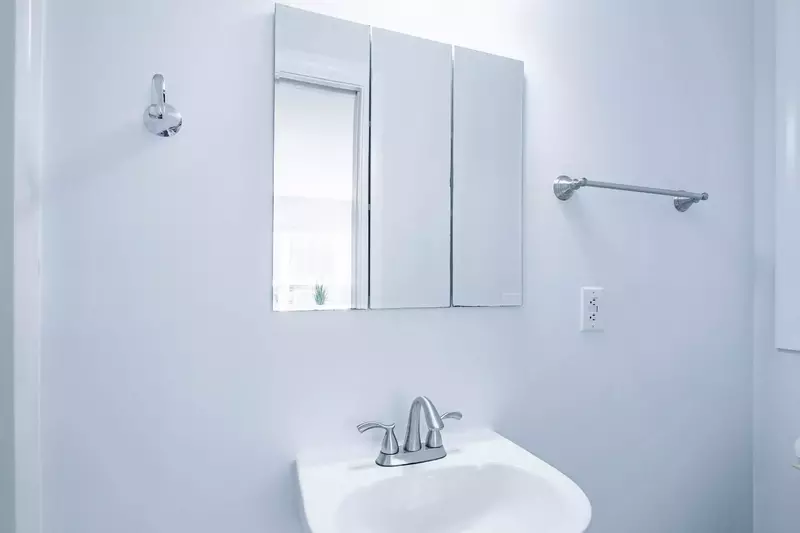 The en suite bathroom features a pedestal sink and a medicine cabinet.