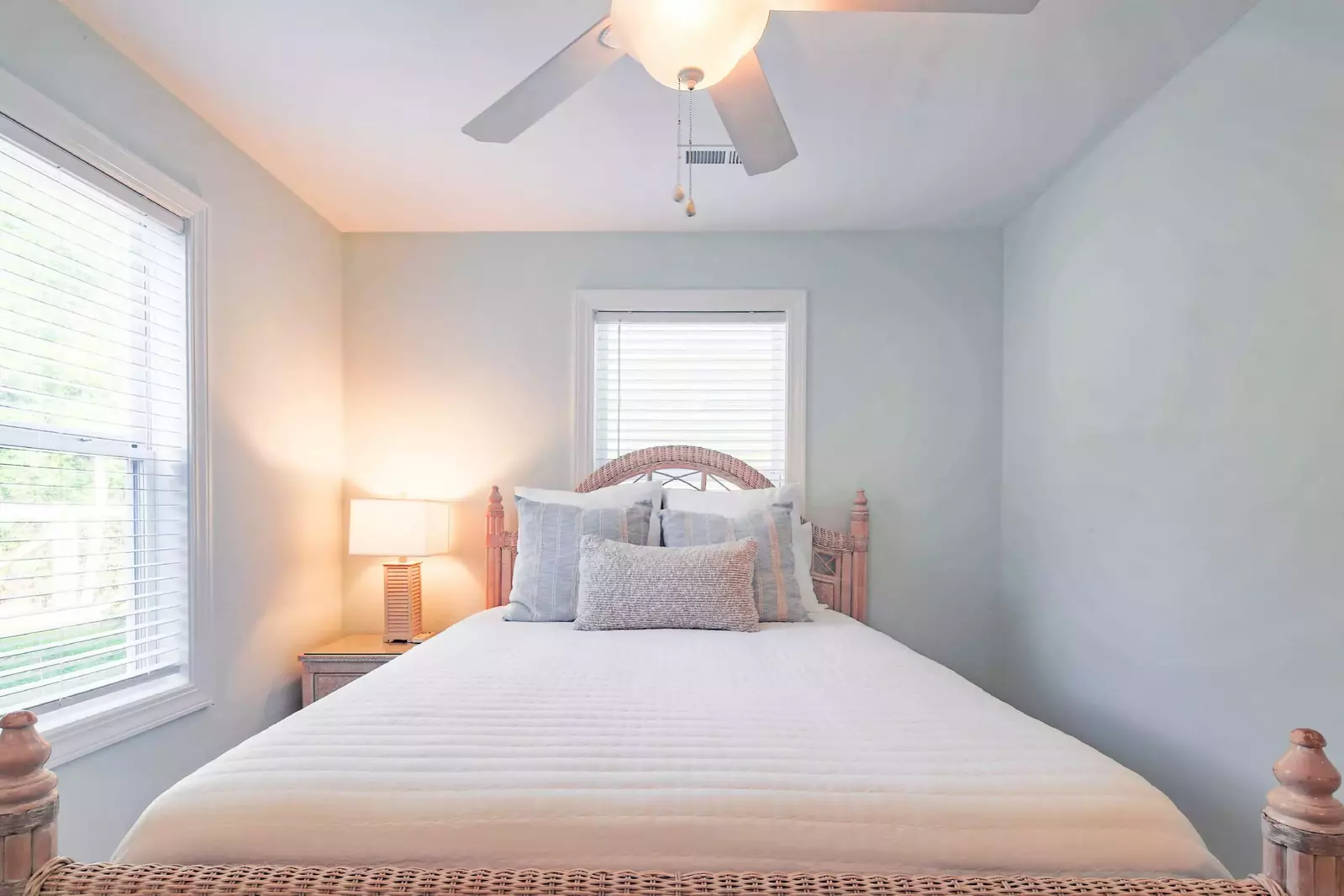 The queen bedroom features a queen bed, night stand with reading lamp and a ceiling fan.