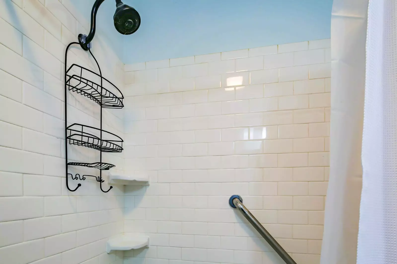 The hallway bathroom also features a tiled shower.