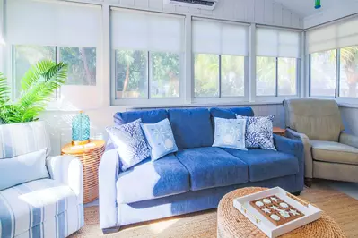 This cozy sunroom is situated off the kitchen with access to the back porch.