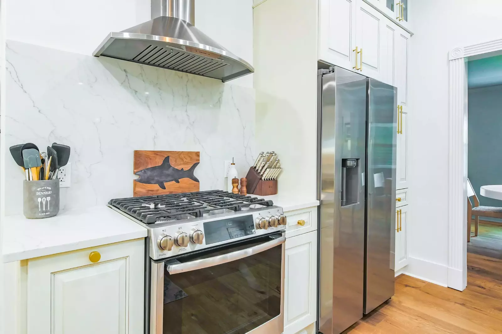 The kitchen features a stainless steel range, refrigerator and hood.
