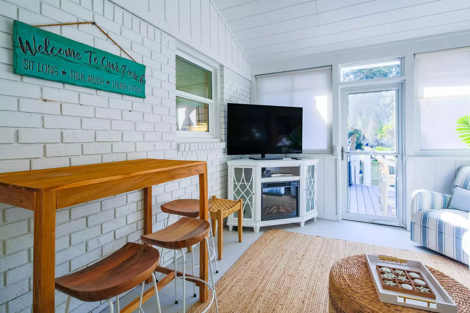 The sunroom features a high top table & stools and a smart TV.