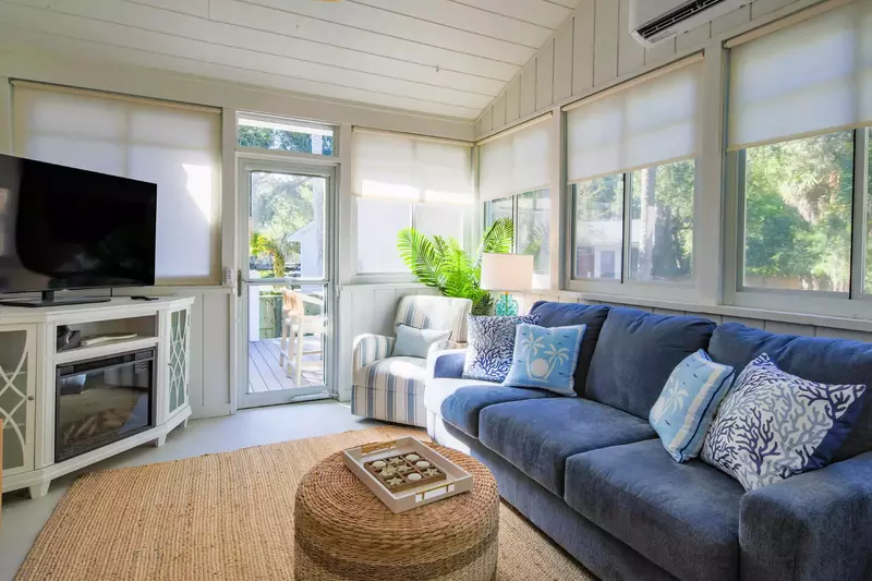 The sunroom also features a comfortable seating area and access to the back deck.