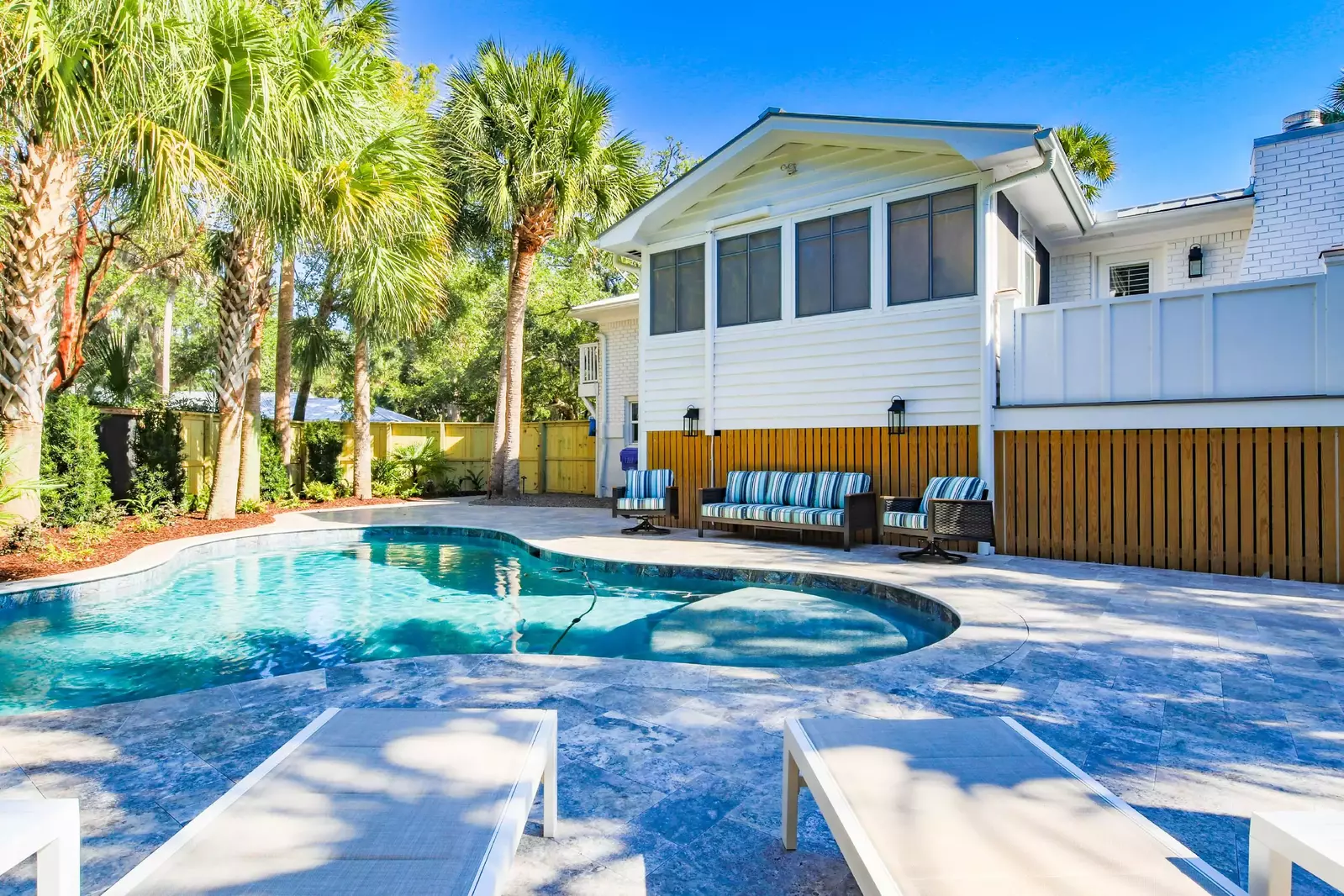 The backyard pool area is enclosed with a privacy fence.