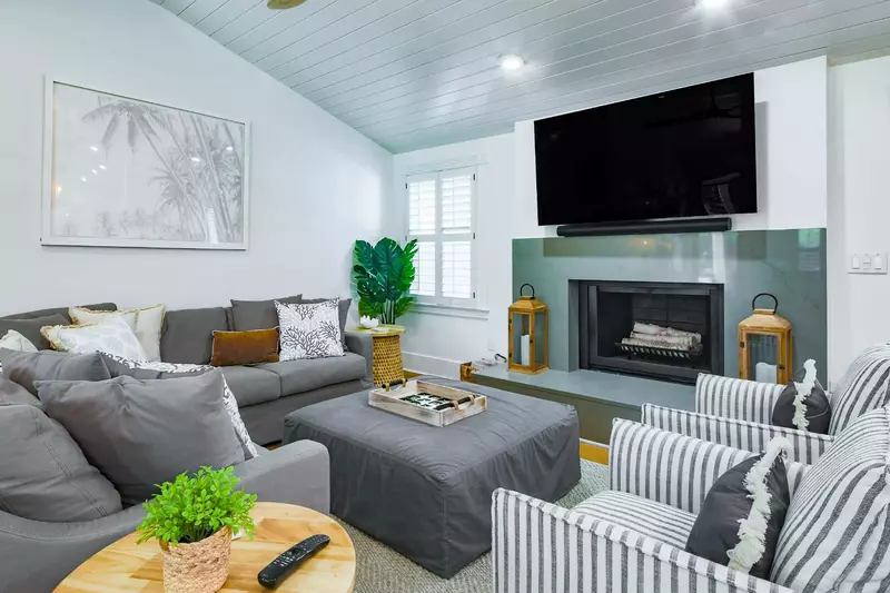 The living room features vaulted shiplap ceilings and a mounted large screen TV.