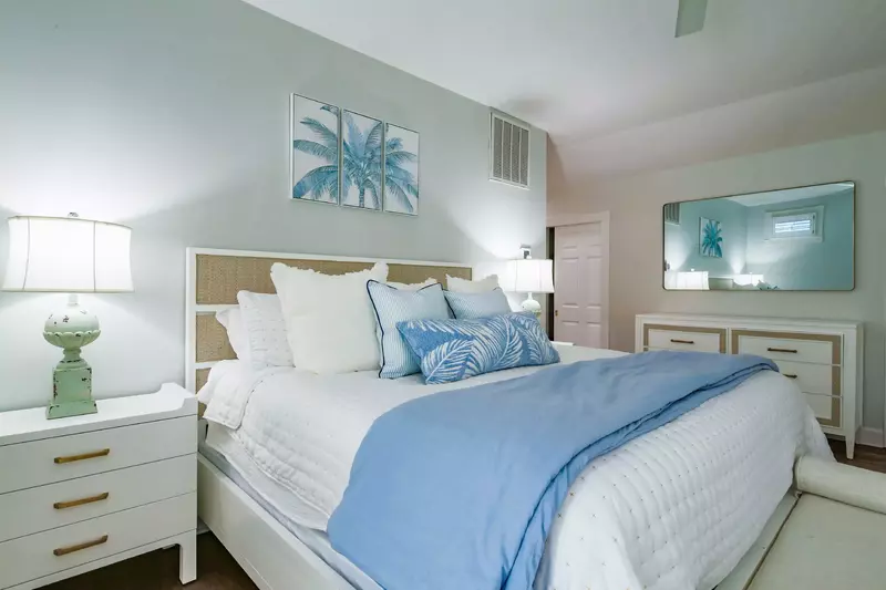 The master suite features a king bed, a dresser and a bench.