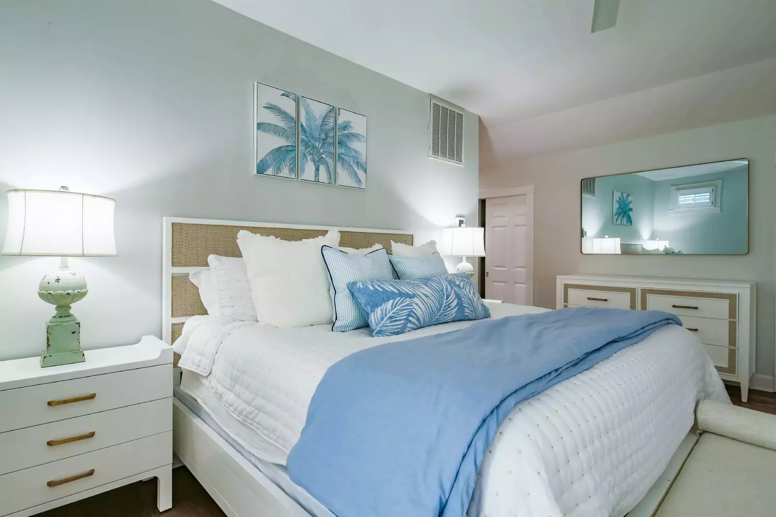 The master suite features a king bed, a dresser and a bench.