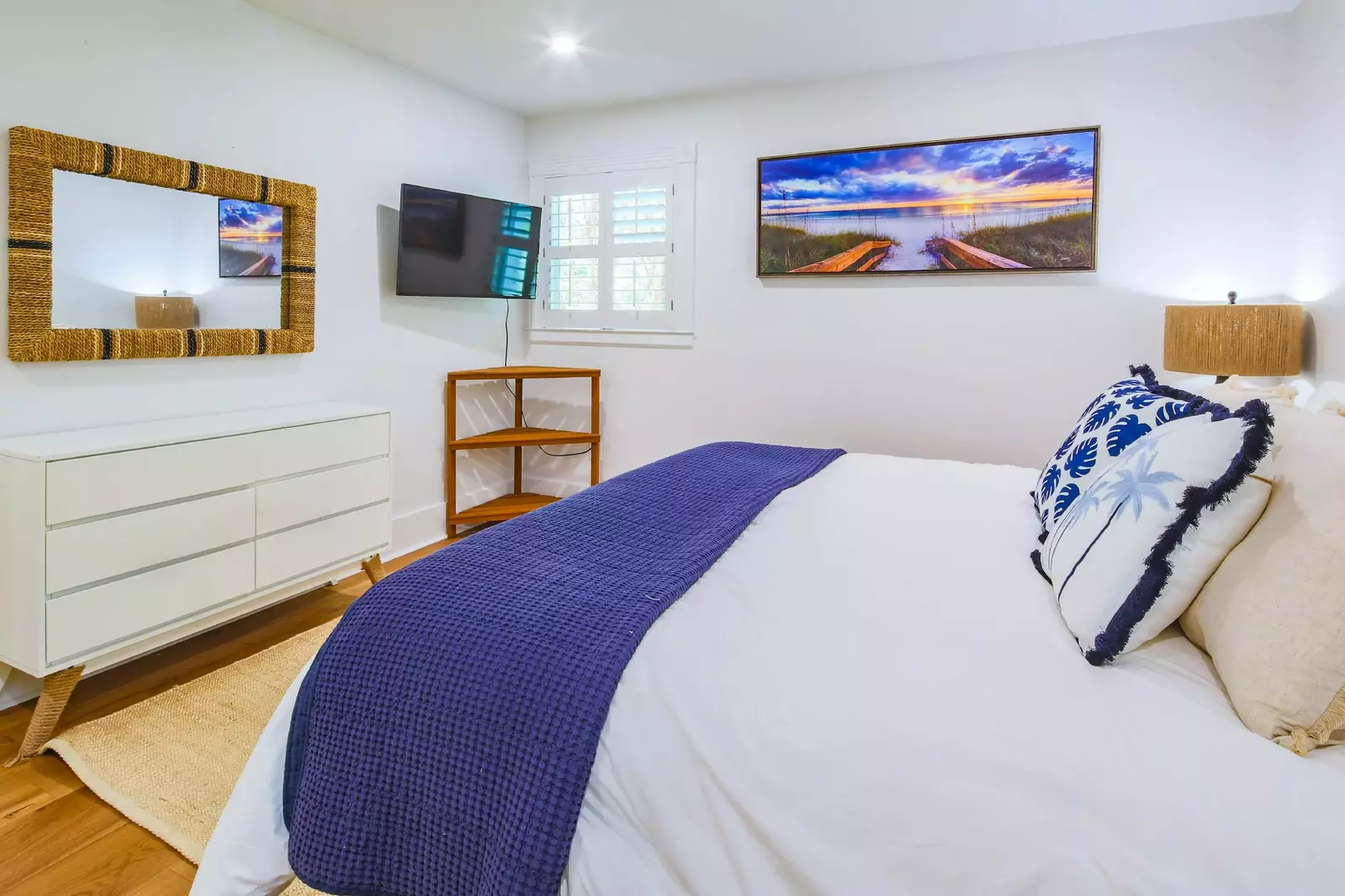 There is a dressser and wall-mounted smart TV in the second master suite.