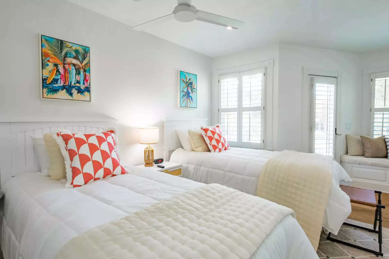 The twin bedroom features two twin beds, a night stand with reading lamp and a ceiling fan.