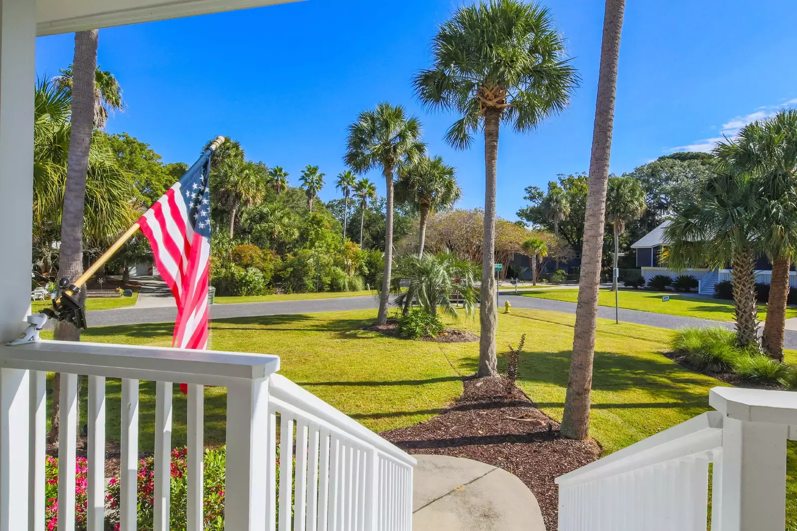 The home features a large front yard with palm trees and tropical landscaping.