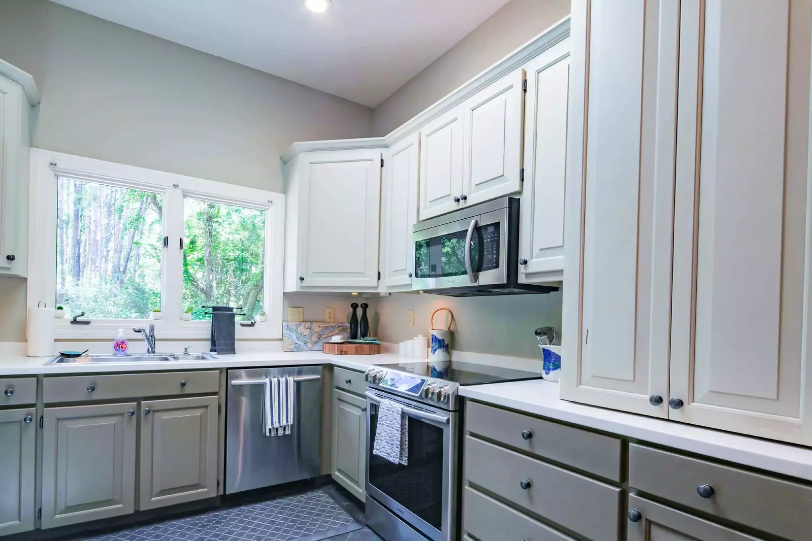 The kitchen features stainless steel appliances, vaulted ceilings and a large picture window above the sink.