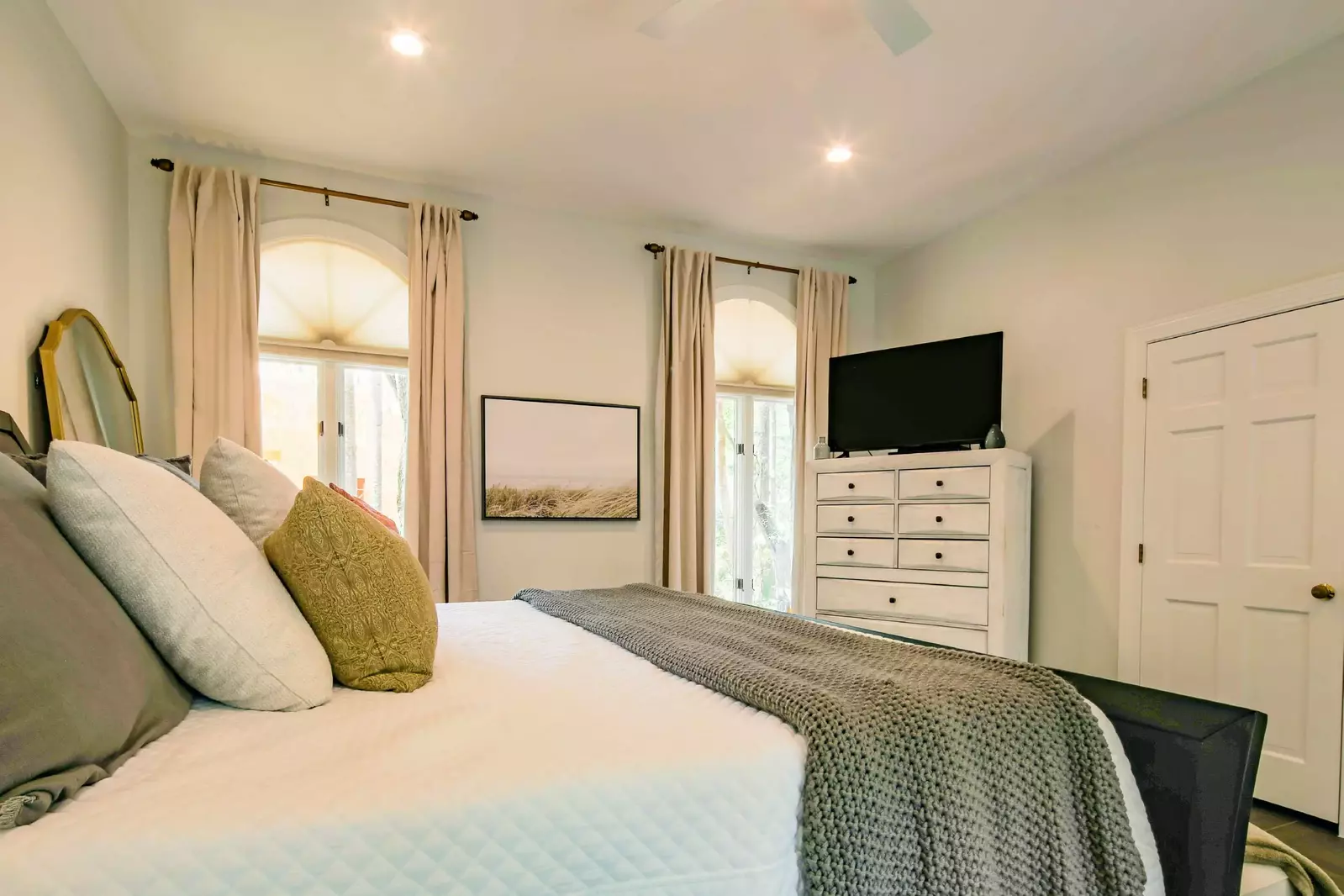 This guest bedroom also features a dresser, flat screen TV and ceiling fan.