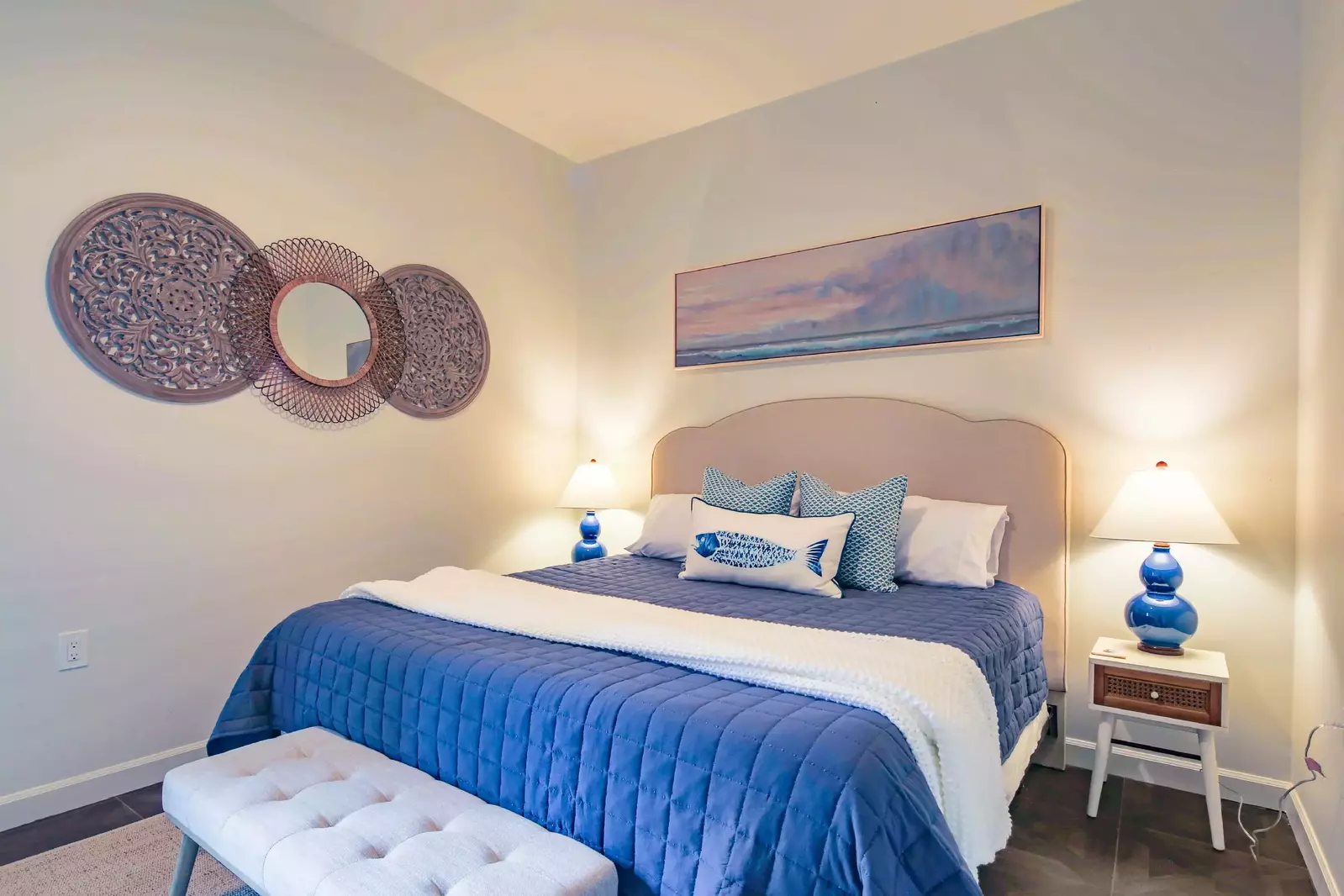 This guest bedroom features a king bed, night stands with reading lamps, new flooring and new furniture.